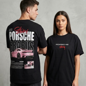 Front and back view of a male and female model displaying a black unisex oversized streetwear t-shirt with a pink Porsche 911 Brabus supercar graphic, bold white block lettering, and red script font accents.